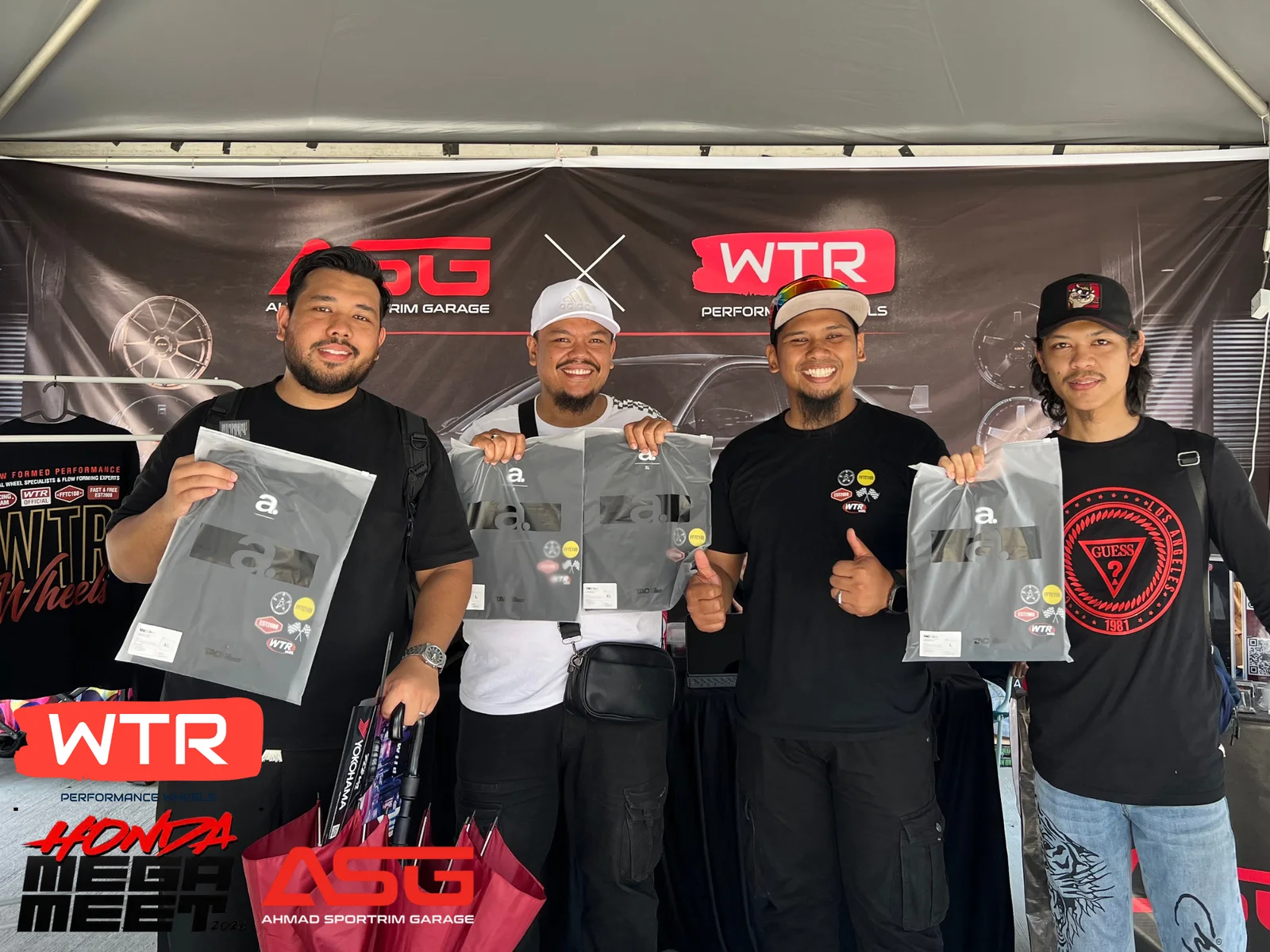 Four community members holding prizes at the ASG and WTR booth
