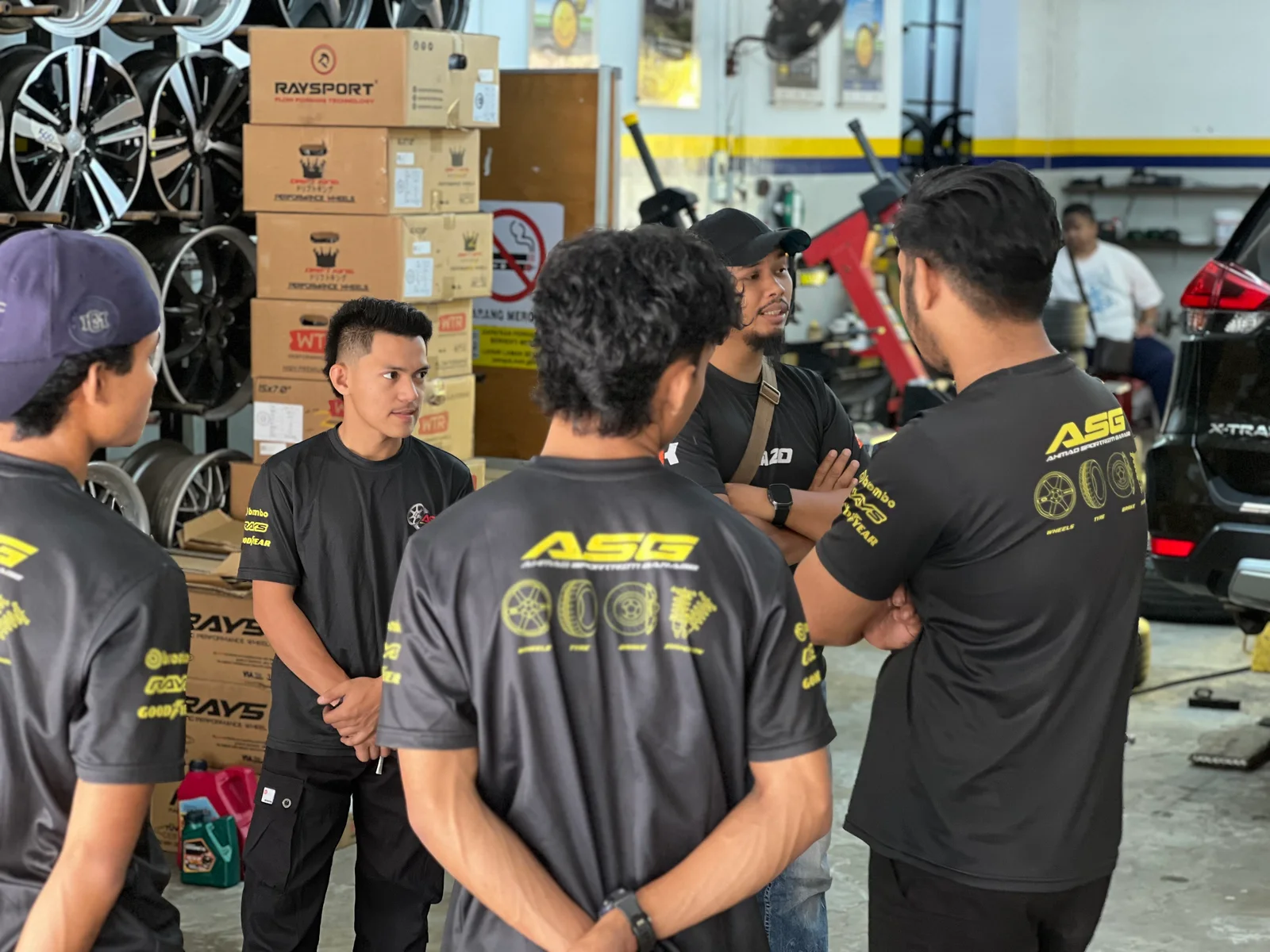 ASG team discussing a vehicle setup inside the workshop