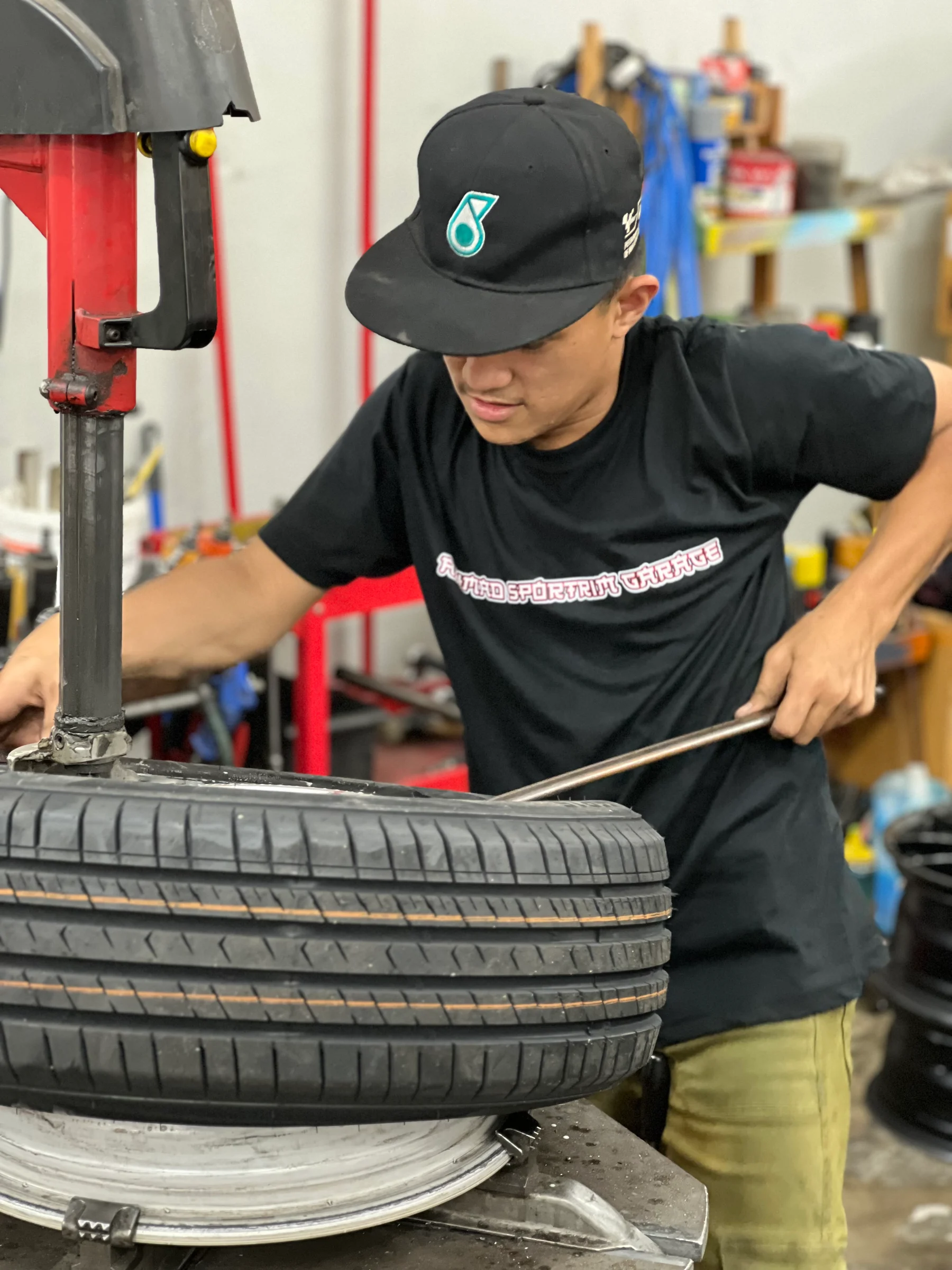 ASG workshop team member fitting a tyre onto a wheel