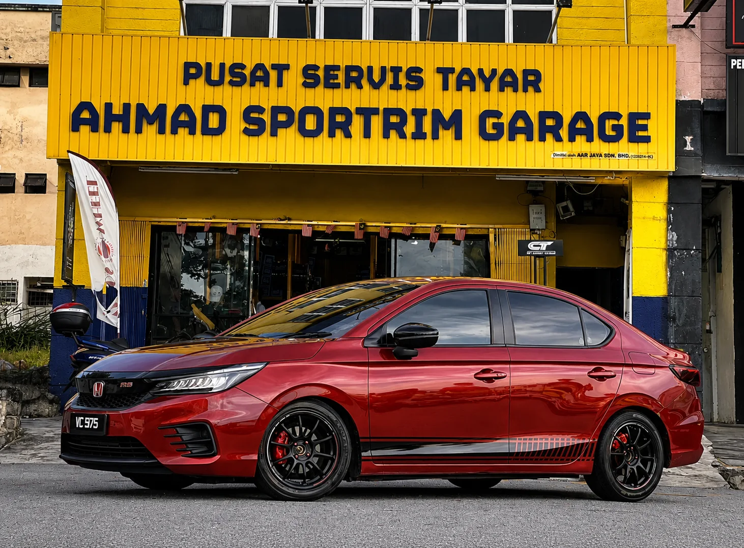 Red Honda Civic sedan with dark multi-spoke wheels outside ASG