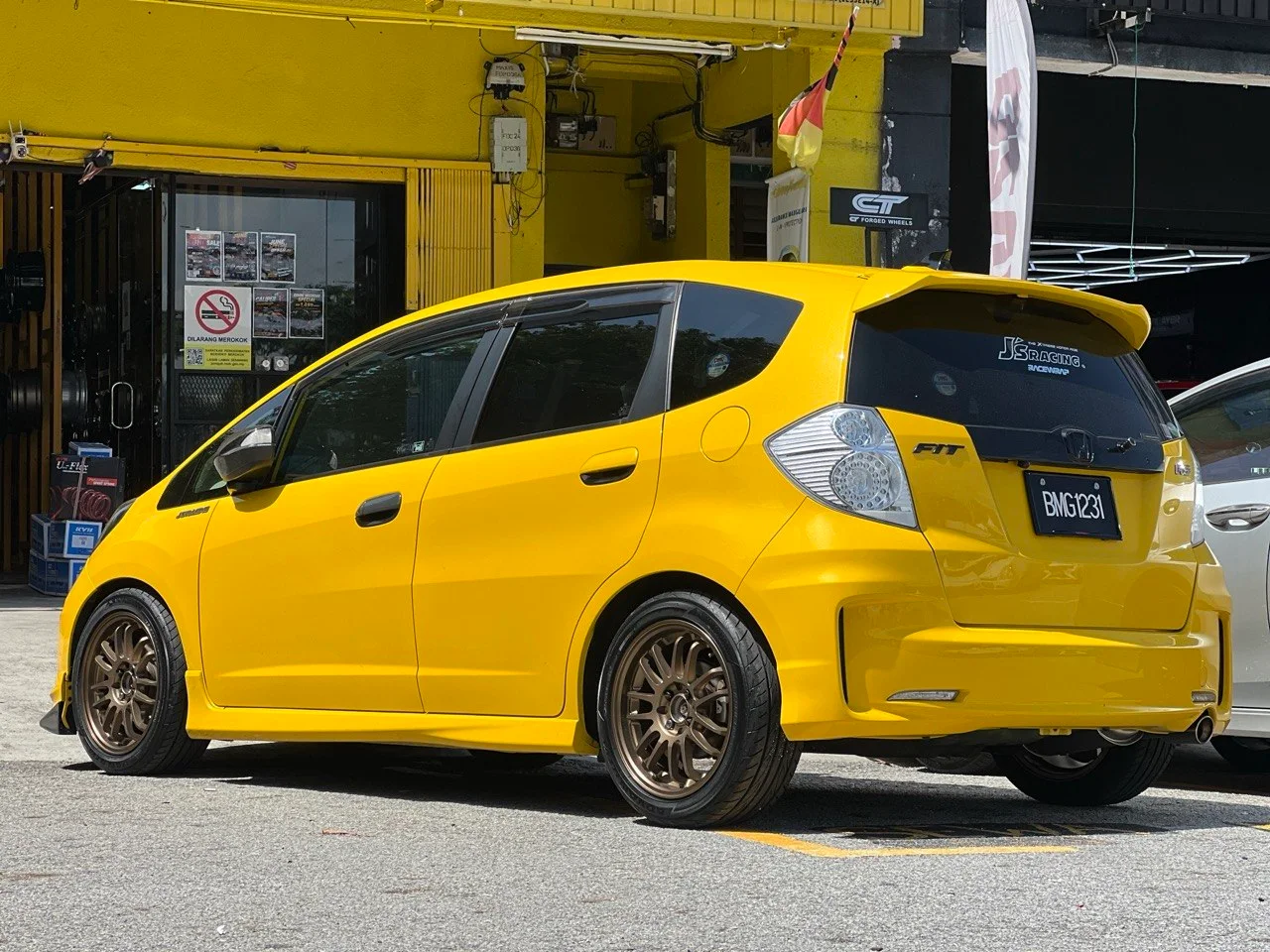 Yellow Honda Jazz with bronze multi-spoke wheels outside ASG