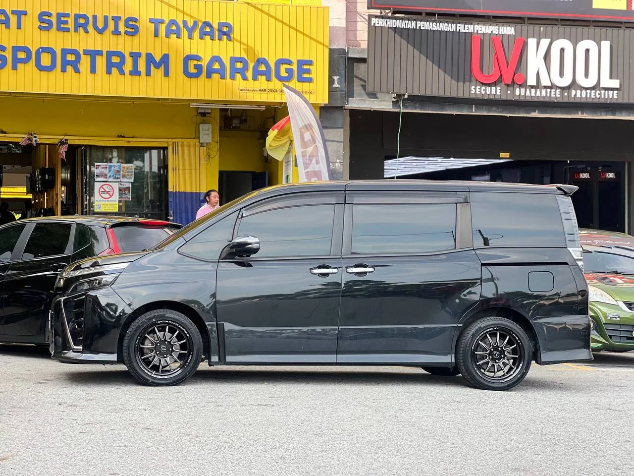 Dark Toyota luxury MPV with multi-spoke wheels outside ASG