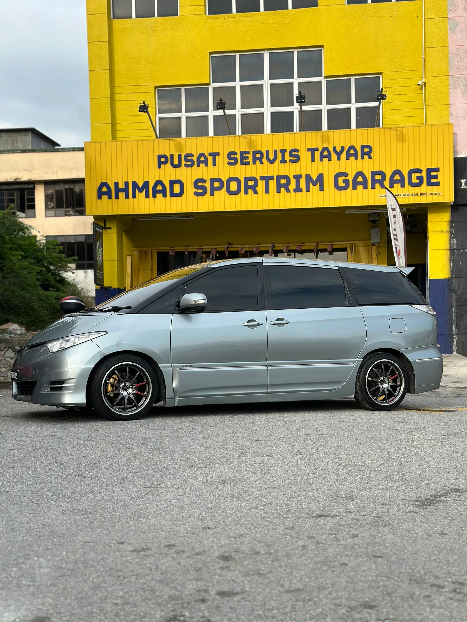 Silver Toyota Estima with dark multi-spoke wheels outside Ahmad Sportrim Garage