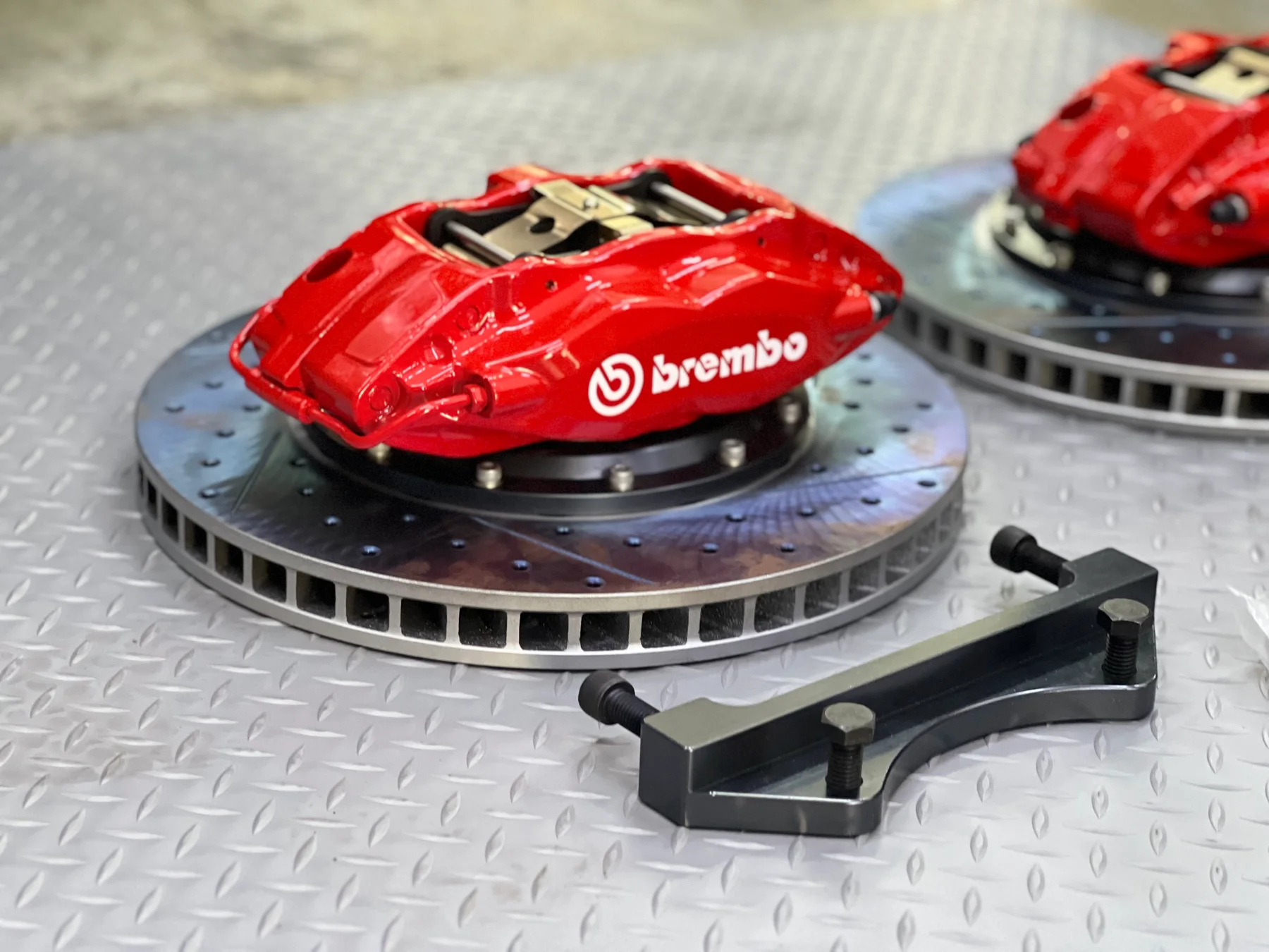 Red Brembo brake calipers and ventilated discs displayed at ASG