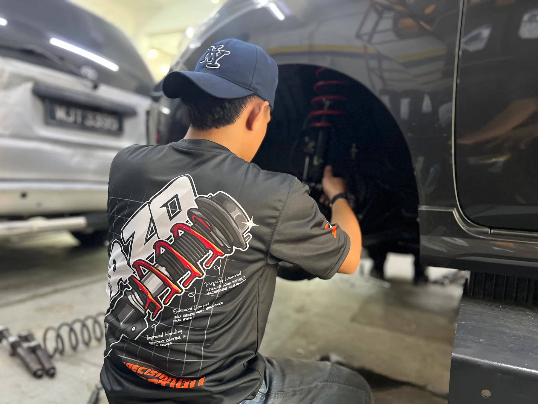 ASG technician installing a suspension component inside a customer car wheel arch