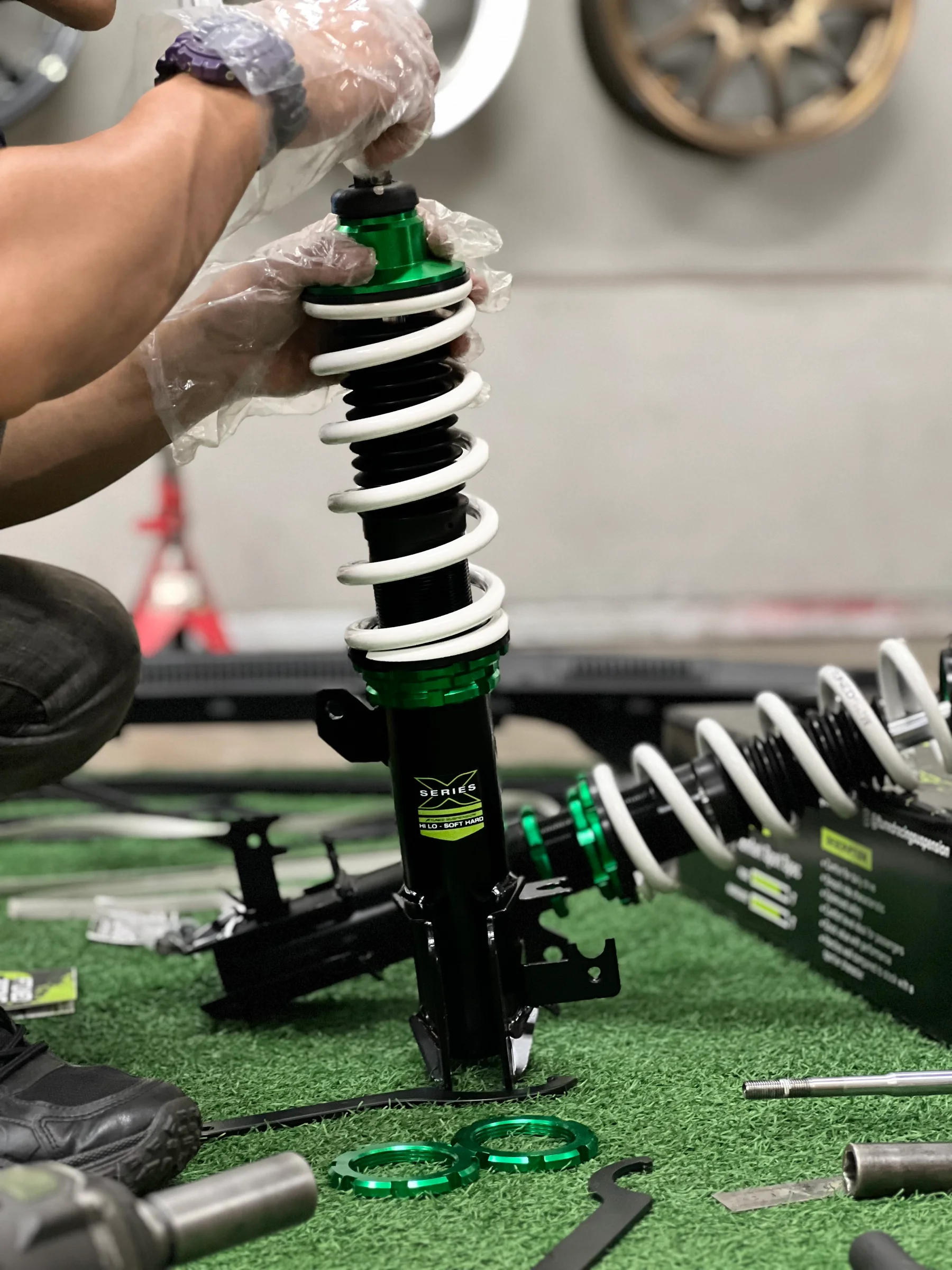 ASG technician assembling an adjustable coilover suspension unit