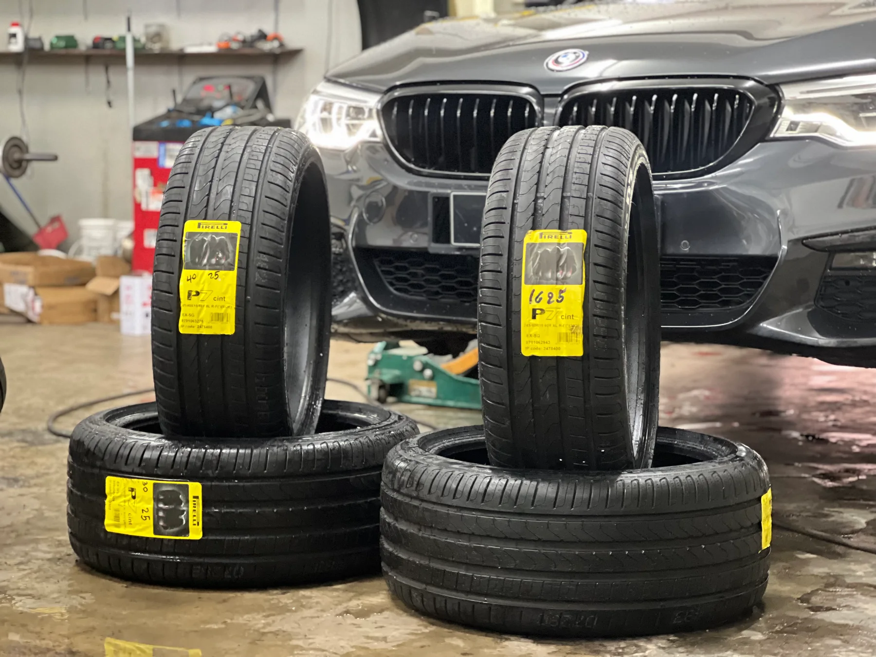 New tyres prepared beside a BMW in the ASG workshop