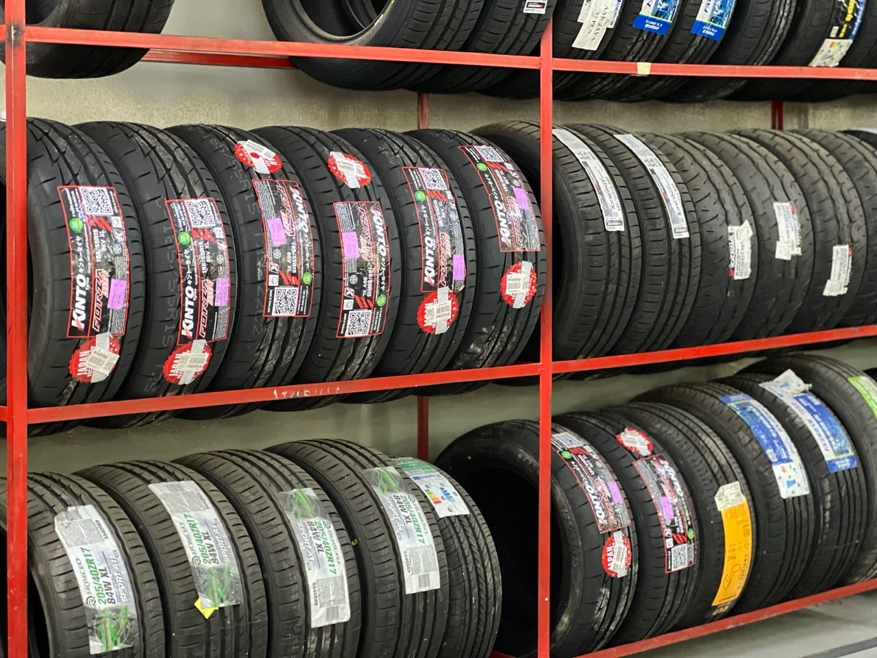 Assorted tyre brands arranged on showroom racks at ASG